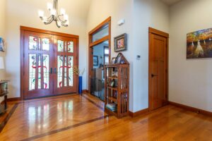 Inviting foyer with hardwood floors and custom stained glass doors inside 5841 Willow Springs Way, listed by Andi Dyer