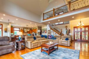 Spacious living room with vaulted ceilings and large windows overlooking the backyard, located at 5841 Willow Springs Way, listed by Andi Dyer