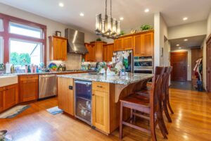 Expansive view of the open-concept kitchen and dining area featuring modern appliances, granite countertops, and hardwood floors, listed by Andi Dyer