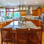 Close-up of kitchen island with built-in sink and granite countertop in a well-equipped kitchen, listed by Andi Dye