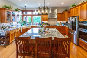 Close-up of kitchen island with built-in sink and granite countertop in a well-equipped kitchen, listed by Andi Dye