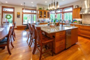 Full view of the spacious kitchen from the dining area showing ample cabinetry and modern lighting, listed by Andi Dyer