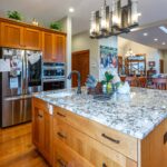 Detailed kitchen view highlighting stainless steel appliances, cherry wood cabinets, and granite countertops, listed by Andi Dyer