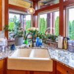 Kitchen counter view showcasing the farmhouse sink, granite countertops, and decorative window garden, listed by Andi Dyer