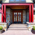 Detailed front porch view at 5841 Willow Springs Way with decorative doors and American flag, listed by Andi Dyer