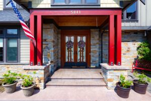 Detailed front porch view at 5841 Willow Springs Way with decorative doors and American flag, listed by Andi Dyer