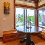 Dining area with a large wooden table set against the background of a fully equipped kitchen, listed by Andi Dyer.