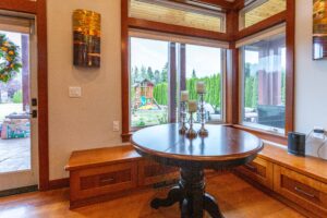 Dining area with a large wooden table set against the background of a fully equipped kitchen, listed by Andi Dyer.