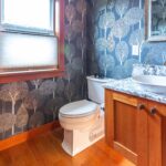 Powder room featuring distinctive tree-patterned wallpaper and modern fixtures, listed by Andi Dyer