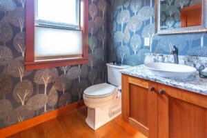 Powder room featuring distinctive tree-patterned wallpaper and modern fixtures, listed by Andi Dyer