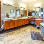 Expansive bathroom featuring dual vanities and freestanding tub, listed by Andi Dyer