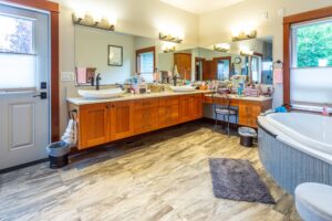 Expansive bathroom featuring dual vanities and freestanding tub, listed by Andi Dyer