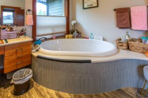 Detail view of a luxury bathtub with stylish surround, ideal for relaxation, listed by Andi Dyer.