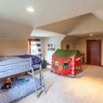 This space is designed for creativity and play, featuring a bunk bed, a play tent, and a variety of toys. Listed by Andi Dyer.