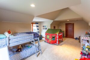 This space is designed for creativity and play, featuring a bunk bed, a play tent, and a variety of toys. Listed by Andi Dyer.