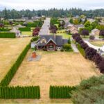 Captures an overhead view of residential homes set within a lush landscape. Listed by Andi Dyer.